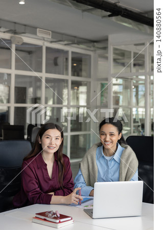 Happy business partners at desk with laptop Happy business partners at desk with laptop 140880564