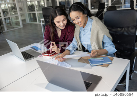Female colleagues studying documents Female colleagues studying documents 140880584