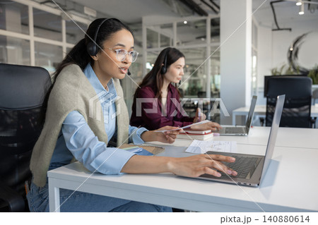 Woman using laptop and headset 140880614