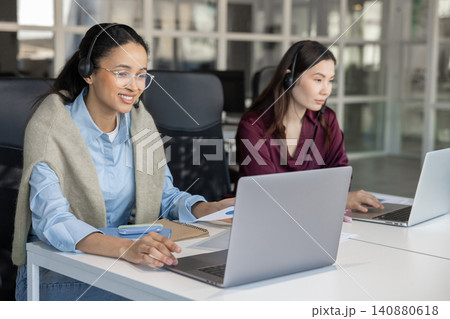 Diverse call center agents working on laptops Diverse call center agents working on laptops 140880618