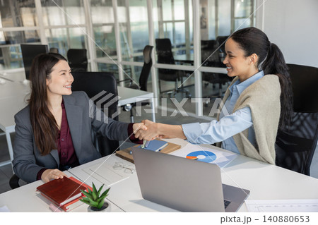 Happy female colleagues handshaking after successful talk 140880653