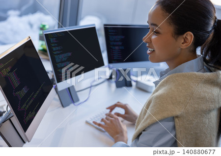 Cheerful woman programmer working with code in office Cheerful woman programmer working with code in office 140880677