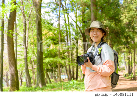 山でカメラを持って微笑む日本人女性 山でカメラを持って微笑む日本人女性 140881111
