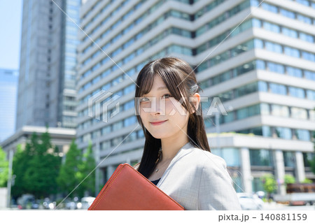 ビル街でバインダーを持つ日本人女性 ビル街でバインダーを持つ日本人女性 140881159