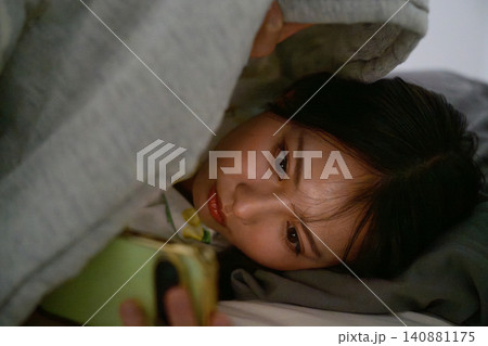 スマホ依存で不眠症に悩む日本人女性 スマホ依存で不眠症に悩む日本人女性 140881175