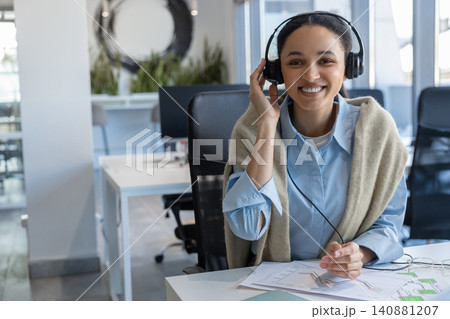 Smiling female operator touching headset Smiling female operator touching headset 140881207