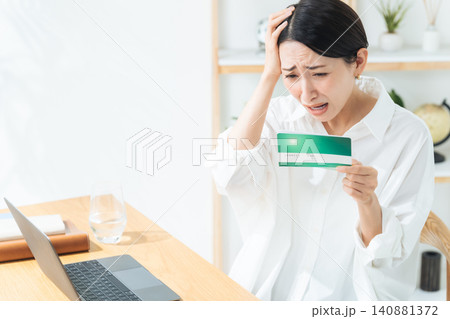 通帳を見て悩む女性。貯金、銀行、ショック、がっかり、悩む、困る、不安、心配、不満、家計、お金、マネー 通帳を見て悩む女性。貯金、銀行、ショック、がっかり、悩む、困る、不安、心配、不満、家計、お金、マネー 140881372