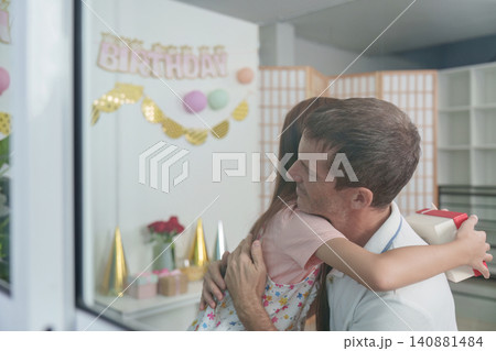 Loving daughter hugging father during birthday celebration at home Loving daughter hugging father during birthday celebration at home 140881484