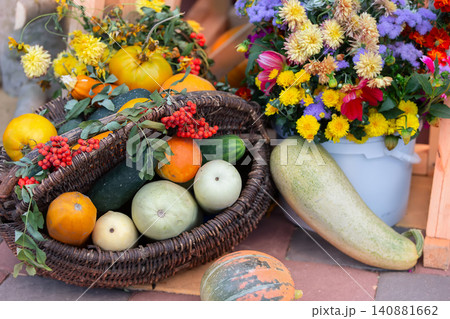 Colorful harvest display with fresh vegetables and vibrant flowers at a local market in autumn 140881662