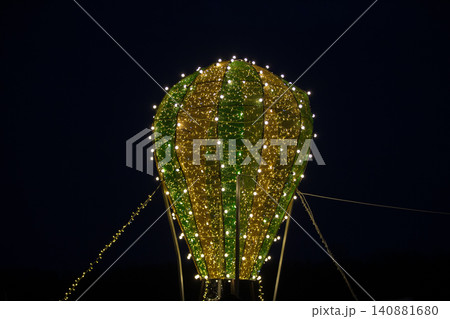 Illuminated hot air balloon decoration shines brightly against the night sky at a festive event 140881680