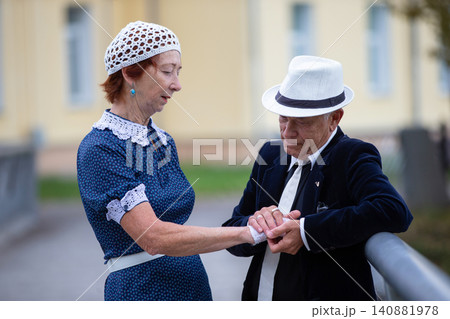 Elderly pair shares a gentle moment near the building in the late after Elderly pair shares a gentle moment near the building in the late after 140881978
