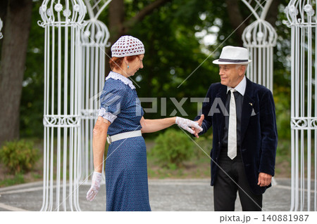 Elegant couple shares a dance under ornate gazebo during a sunny afternoon in the park Elegant couple shares a dance under ornate gazebo during a sunny afternoon in the park 140881987