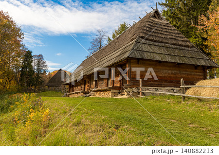 Rustic log cabin settlement nestled in a vibrant autumn countryside landscape Rustic log cabin settlement nestled in a vibrant autumn countryside landscape 140882213