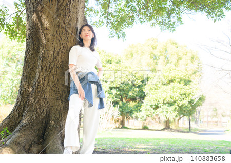 木にもたれてリラックスする日本人女性 木にもたれてリラックスする日本人女性 140883658