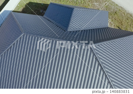 House with a gray metal roof. Corrugated metal roof and metal roofing. Modern roof made of metal. House with a gray metal roof. Corrugated metal roof and metal roofing. Modern roof made of metal. 140883831