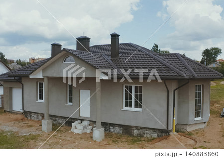 House with a brown metal roof.Corrugated metal roof and metal roofing. Modern roof made of metal. House with a brown metal roof.Corrugated metal roof and metal roofing. Modern roof made of metal. 140883860