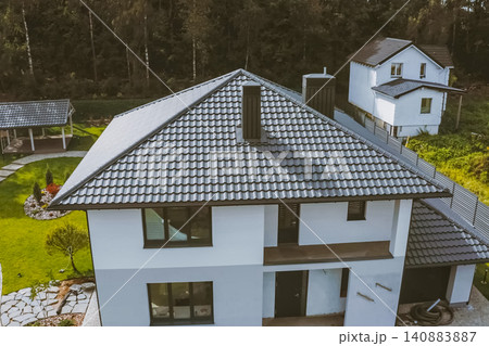 House with a gray metal roof. Corrugated metal roof and metal roofing. Modern roof made of metal. 140883887