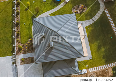 House with a gray metal roof. Corrugated metal roof and metal roofing. Modern roof made of metal. House with a gray metal roof. Corrugated metal roof and metal roofing. Modern roof made of metal. 140883892