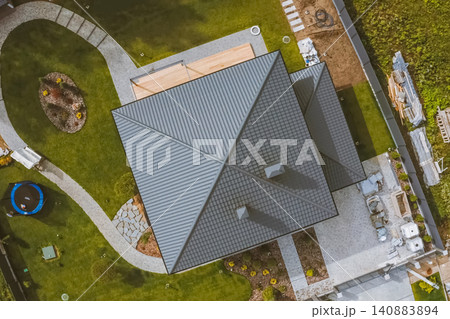 House with a gray metal roof. Corrugated metal roof and metal roofing. Modern roof made of metal. House with a gray metal roof. Corrugated metal roof and metal roofing. Modern roof made of metal. 140883894