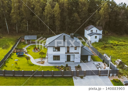 House with a gray metal roof. Corrugated metal roof and metal roofing. Modern roof made of metal. House with a gray metal roof. Corrugated metal roof and metal roofing. Modern roof made of metal. 140883903