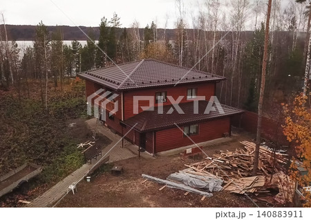 House with a brown metal roof.Corrugated metal roof and metal roofing. Modern roof made of metal. House with a brown metal roof.Corrugated metal roof and metal roofing. Modern roof made of metal. 140883911