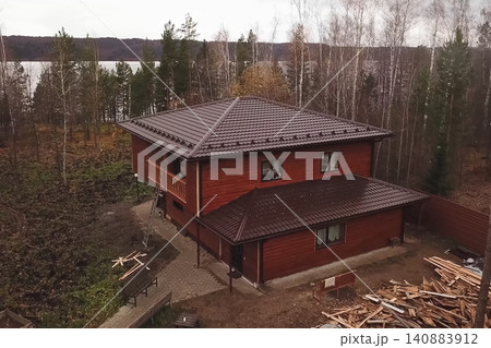House with a brown metal roof.Corrugated metal roof and metal roofing. Modern roof made of metal. House with a brown metal roof.Corrugated metal roof and metal roofing. Modern roof made of metal. 140883912