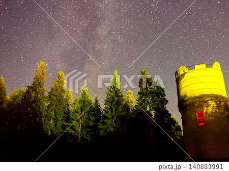 Starry sky over the forest and the water tower. Starry sky background picture of stars in night sky and the Milky Way. Starry sky over the forest and the water tower. Starry sky background picture of stars in night sky and the Milky Way. 140883991