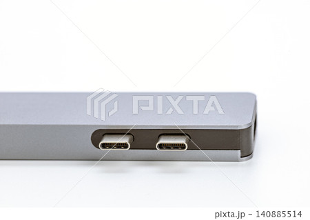 Detailed macro close-up view of two USB Type-C connector ports on the polished silver aluminum side panel of a modern slim laptop computer isolated on a clean white studio background Detailed macro close-up view of two USB Type-C connector ports on the polished silver aluminum side panel of a modern slim laptop computer isolated on a clean white studio background 140885514
