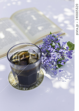 木漏れ日のテーブルで楽しむアイスコーヒーと紫陽花のある夏の読書時間 木漏れ日のテーブルで楽しむアイスコーヒーと紫陽花のある夏の読書時間 140885820