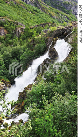 Kleivafossen is one of Norway's most iconic waterfalls, on the way to the Briksdalsbreen glacier Kleivafossen is one of Norway's most iconic waterfalls, on the way to the Briksdalsbreen glacier 140887034
