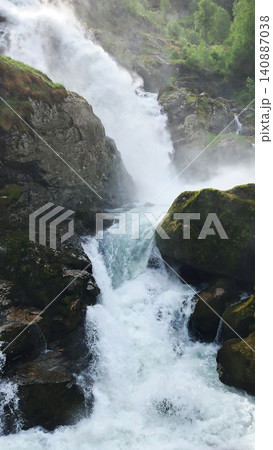 Kleivafossen is one of Norway's most iconic waterfalls, on the way to the Briksdalsbreen glacier Kleivafossen is one of Norway's most iconic waterfalls, on the way to the Briksdalsbreen glacier 140887038