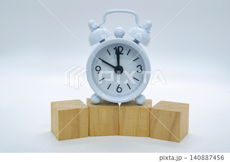 Wooden cube platform with vintage alarm clock on a bright white background for elegant product mockup presentations. Wooden cube platform with vintage alarm clock on a bright white background for elegant product mockup presentations. 140887456