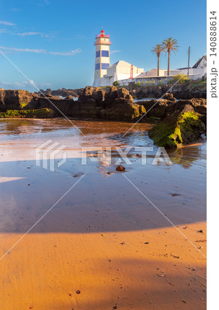 Santa Marta Lighthouse on sandy beach with rocky coast in Cascais, Portugal 140888614