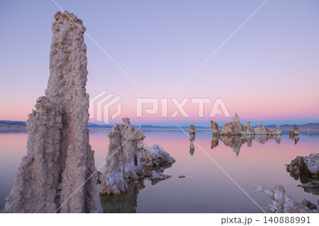 Sierra nevada california tufa lake sunrise pastel sky calm water reflection at dawn with mineral tower and serene desert shore Sierra nevada california tufa lake sunrise pastel sky calm water reflection at dawn with mineral tower and serene desert shore 140888991