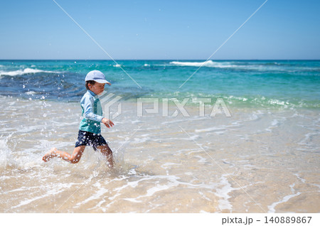 Playful 5-Year-Old Boy Running Through Shallow Waves at Sri Lankan Beach Playful 5-Year-Old Boy Running Through Shallow Waves at Sri Lankan Beach 140889867