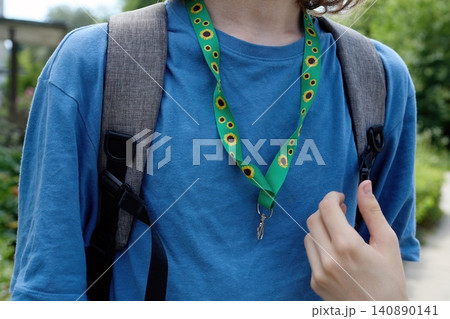 Person wearing sunflower lanyard for hidden disabilities awareness Person wearing sunflower lanyard for hidden disabilities awareness 140890141