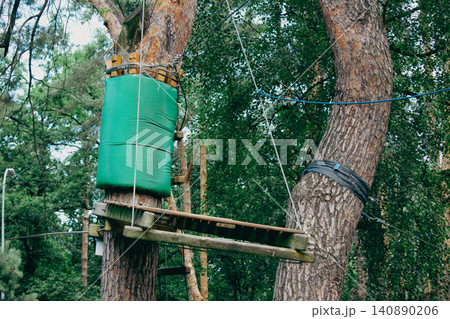 Rope adventure park construction details on tree trunks in a forest 140890206