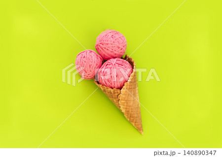 Pink Yarn Balls in Ice Cream Cone on Bright Green Background 140890347