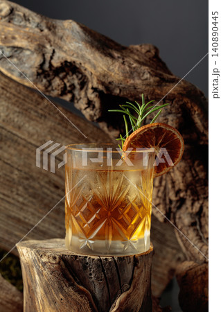 Old-fashioned cocktail with ice on an old wooden stump. Old-fashioned cocktail with ice on an old wooden stump. 140890445