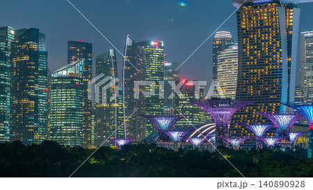 Skyscrapers behind Gardens by the bay with supertrees day to night timelapse after sunset Skyscrapers behind Gardens by the bay with supertrees day to night timelapse after sunset 140890928