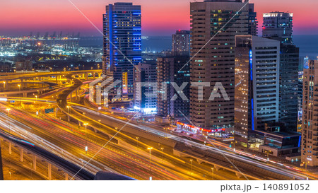 Dubai marina with traffic on sheikh zayed road panorama day to night timelapse lights turn on. Dubai marina with traffic on sheikh zayed road panorama day to night timelapse lights turn on. 140891052