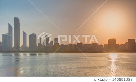Abu Dhabi city skyline on sunrise time with water reflection timelapse. Abu Dhabi city skyline on sunrise time with water reflection timelapse. 140891388
