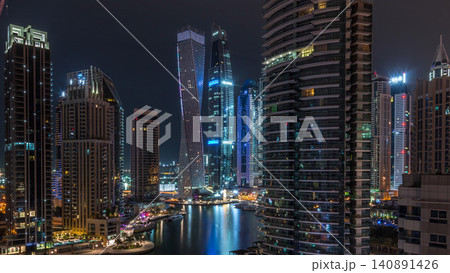 Aerial view of Dubai Marina residential and office skyscrapers with waterfront night timelapse Aerial view of Dubai Marina residential and office skyscrapers with waterfront night timelapse 140891426