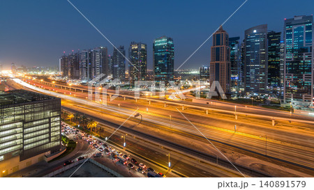 Aerial view of Jumeirah lakes towers skyscrapers day to night timelapse with traffic on sheikh zayed road. Aerial view of Jumeirah lakes towers skyscrapers day to night timelapse with traffic on sheikh zayed road. 140891579