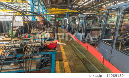 Conveyor assembly stage the body of tractor at big industrial factory timelapse Conveyor assembly stage the body of tractor at big industrial factory timelapse 140891804