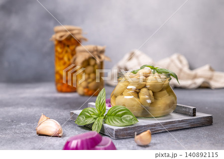 Pickled mushrooms in glass jar with basil and garlic Pickled mushrooms in glass jar with basil and garlic 140892115