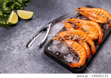 Cooked king prawns on ice with lime and parsley Cooked king prawns on ice with lime and parsley 140892131