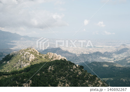 Scenic mountain landscape with lush greenery and distant horizon under blue sky Scenic mountain landscape with lush greenery and distant horizon under blue sky 140892267