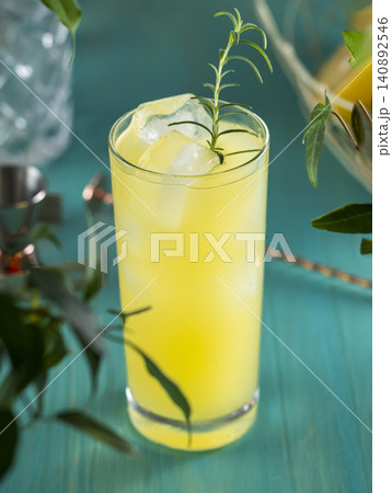 Pear Colins Cocktail. Highball glass filled with pear puree cocktail or mocktails surrounded by ingredients and bar tools on turquoise table surface Pear Colins Cocktail. Highball glass filled with pear puree cocktail or mocktails surrounded by ingredients and bar tools on turquoise table surface 140892546