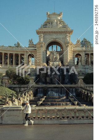 Woman walking by the historic water fountain in a grand architectural setting Woman walking by the historic water fountain in a grand architectural setting 140892756